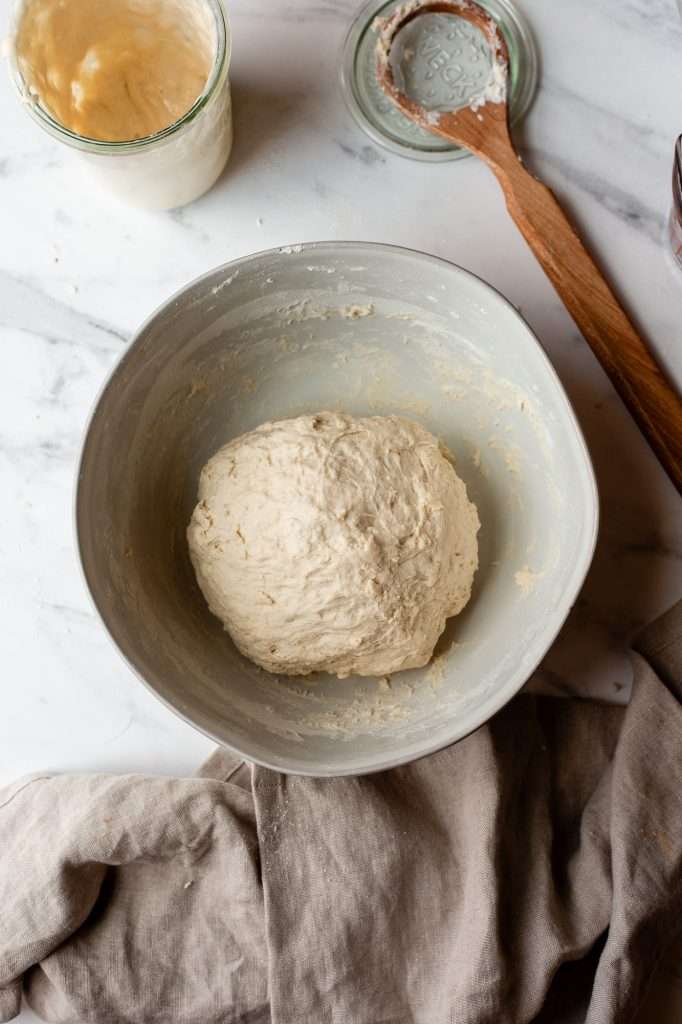 Sourdough bagel dough resting in a mixing bowl.