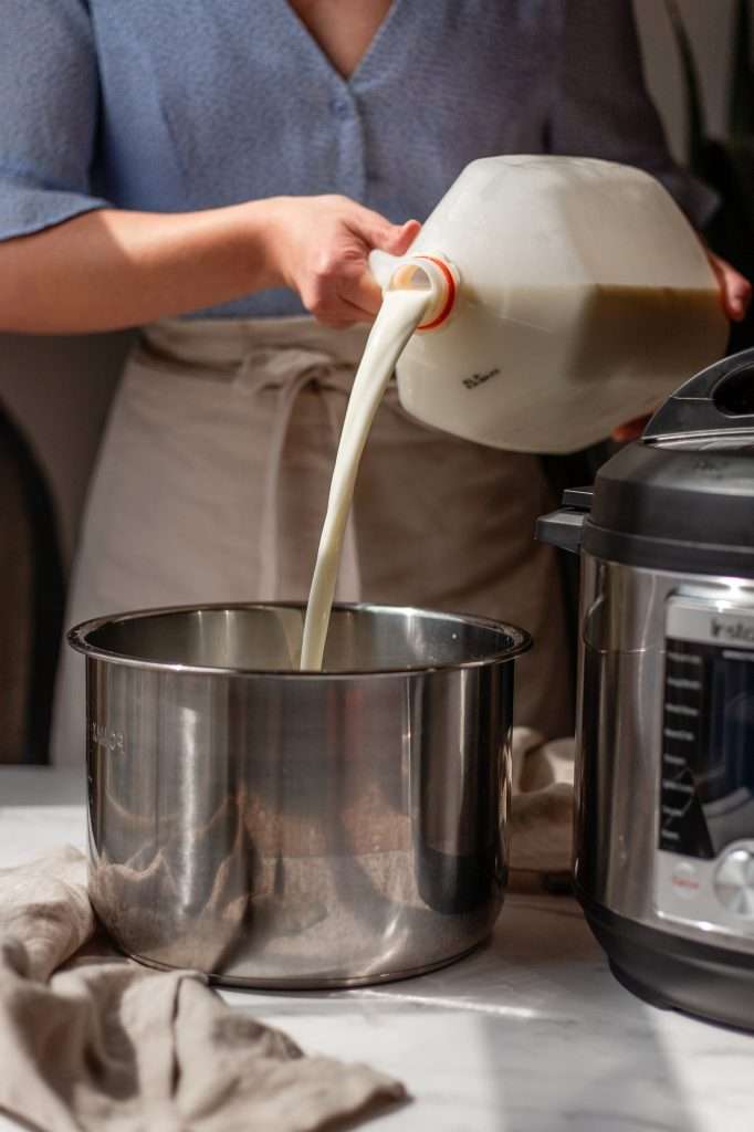 pouring milk into the instant pot insert to make instant pot yogurt. 