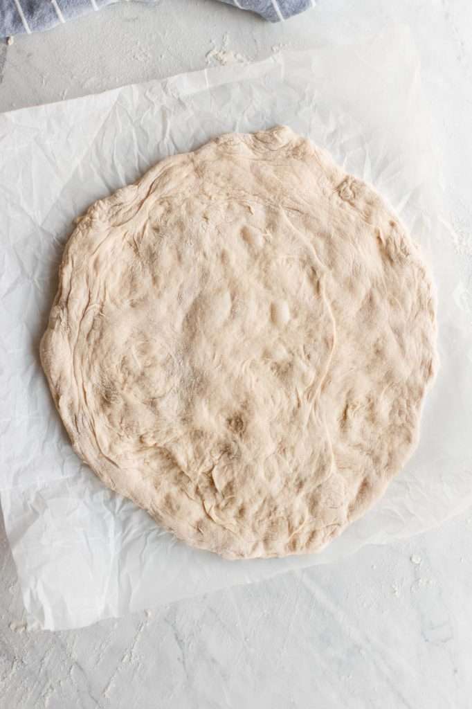 sourdough pizza crust on a piece of crinkly white parchment paper