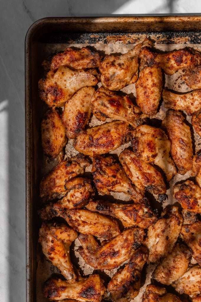 crispy marinated chicken wings on a sheet pan fresh out of the oven.