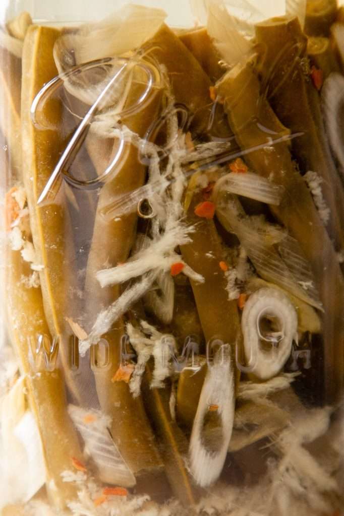 a close up of a ball mason jar filled with fermented green beans