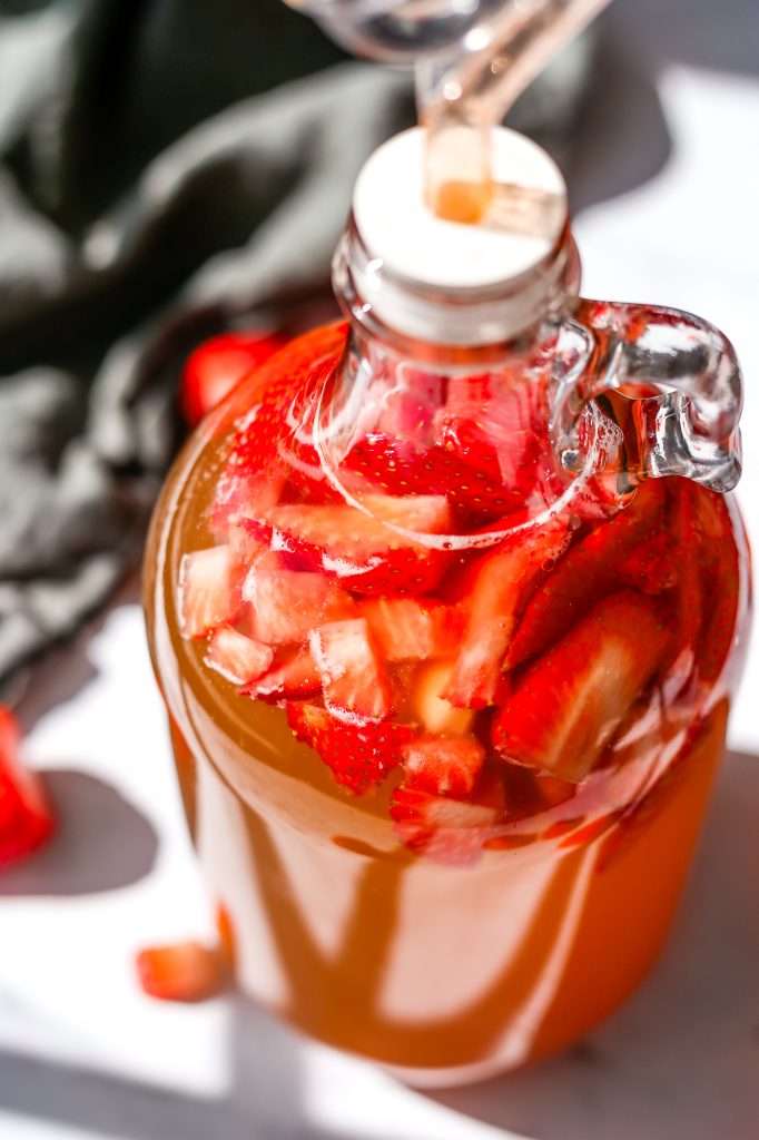 strawberry mead in a half gallon glass jug. 