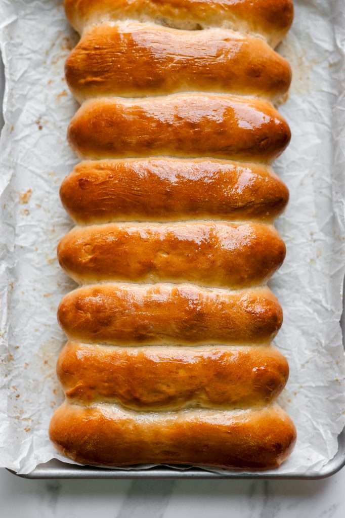 sourdough hot dog buns baked until golden brown and glossy from being brushed with melted butter