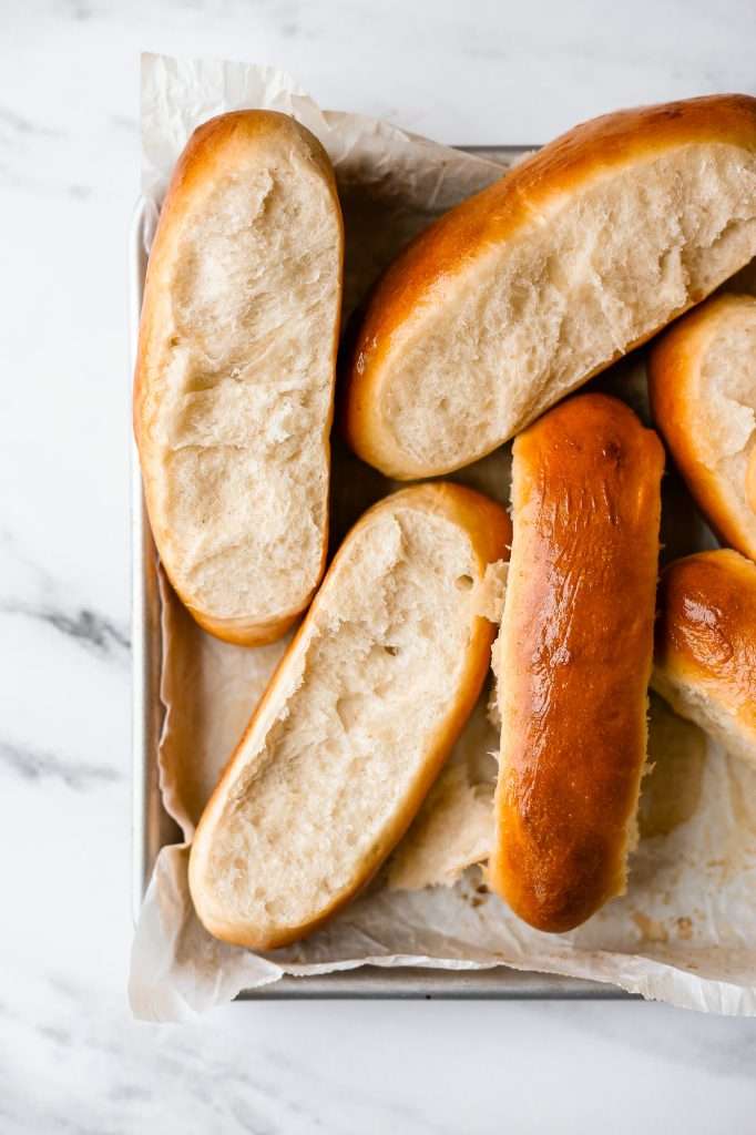 baked sourdough discard hot dog buns on a parchment paper lined baking sheet