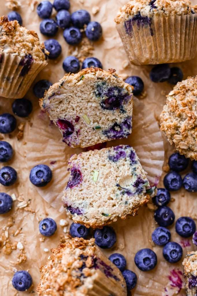 sourdough zucchini blueberry muffin, baked and cut in half to show the inner texture of the muffins with blueberry and zucchini throughout the bake. 