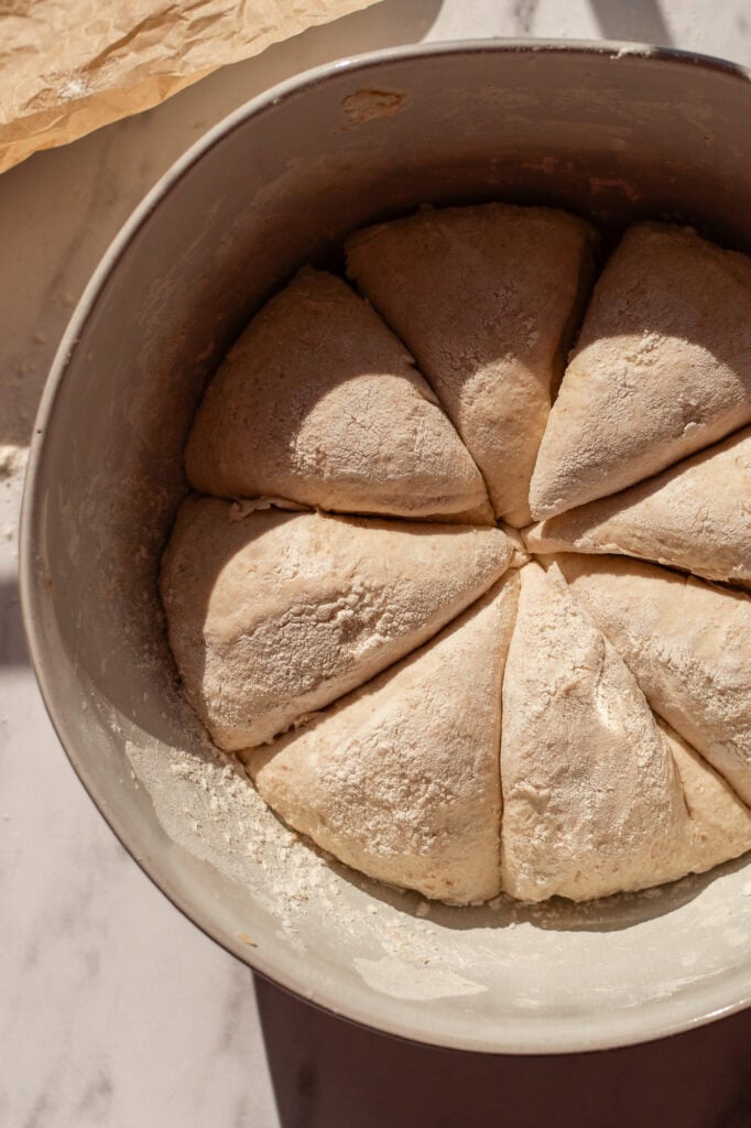 Sourdough cottage cheese bagel dough divided into eight equal portions, ready for shaping.