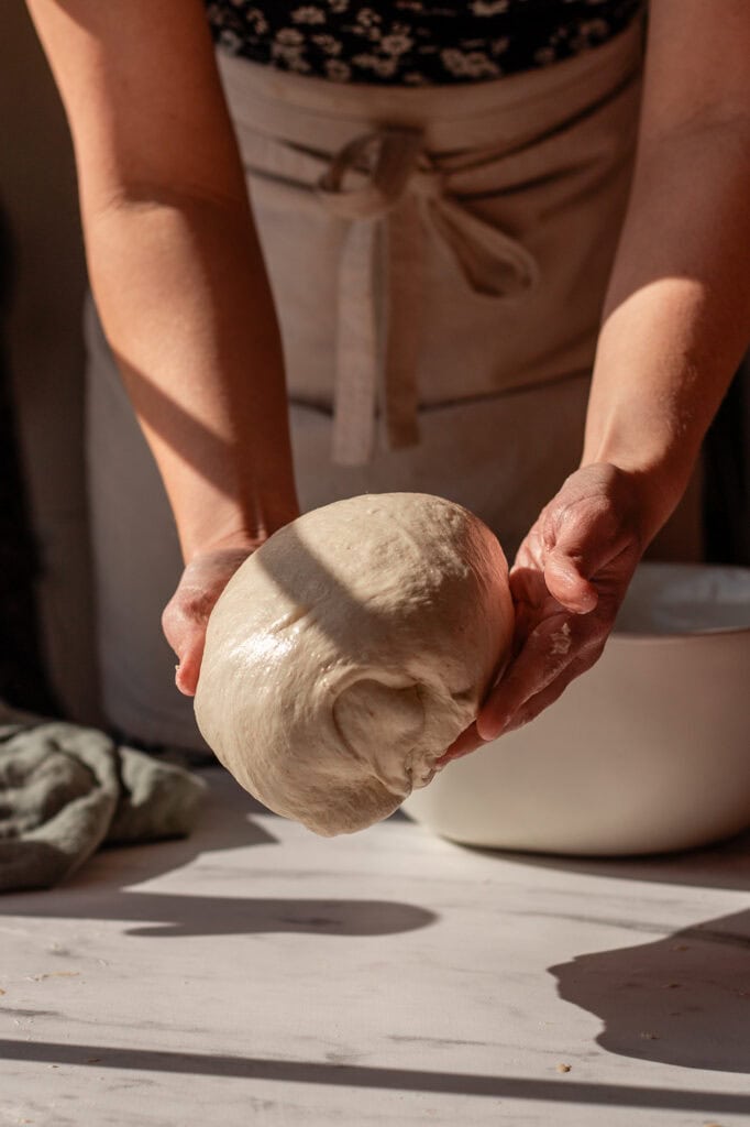 Fully shaped sourdough dough ball, smooth and ready for its next rest period.