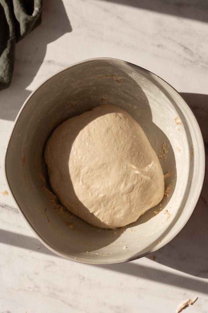 A smooth and elastic sourdough dough ball ready for proofing in the bowl.