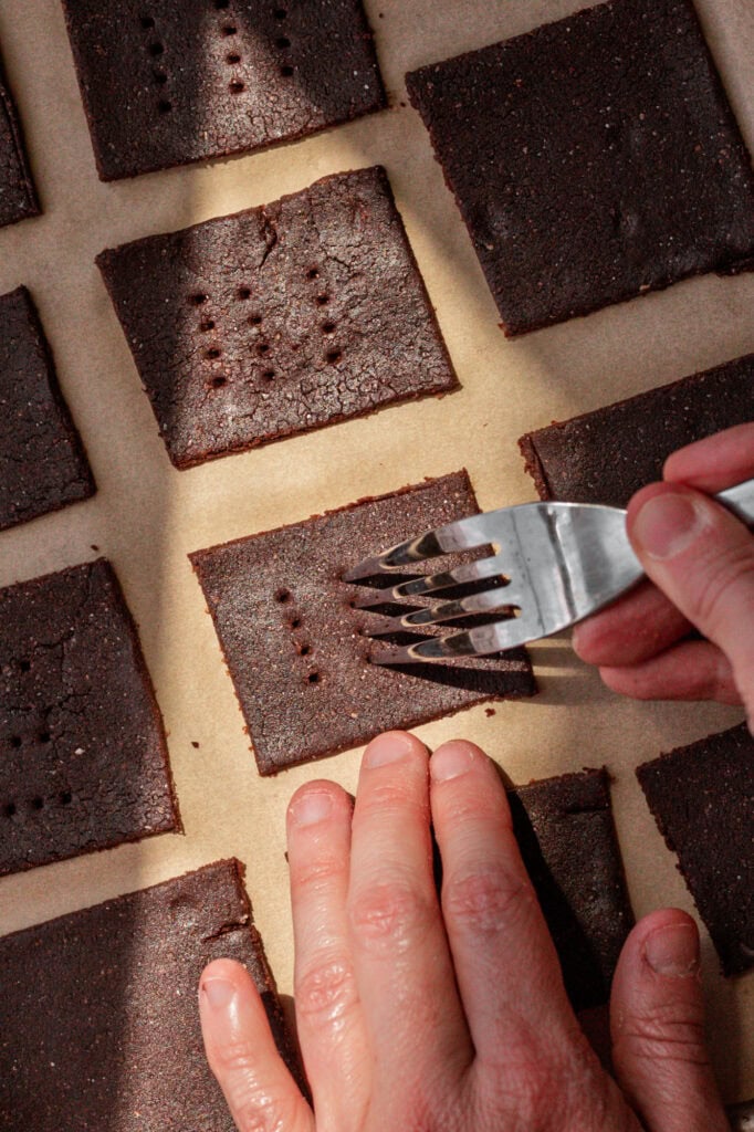 Poking Holes in Sourdough Crackers A fork punctures holes in the sourdough to create the signature cracker texture.