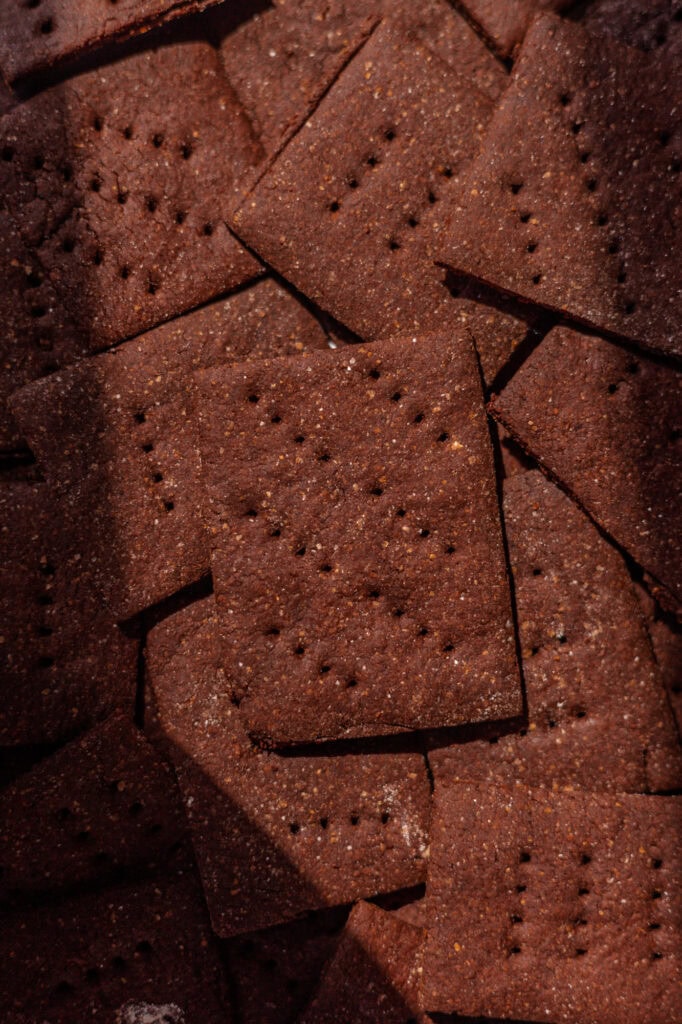 Golden brown baked sourdough chocolate graham crackers laid out in the sunlight.
