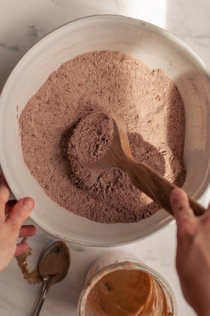 Combine dry ingredients A white bowl holds a mixture of flour, baking soda, salt, and cocoa powder.