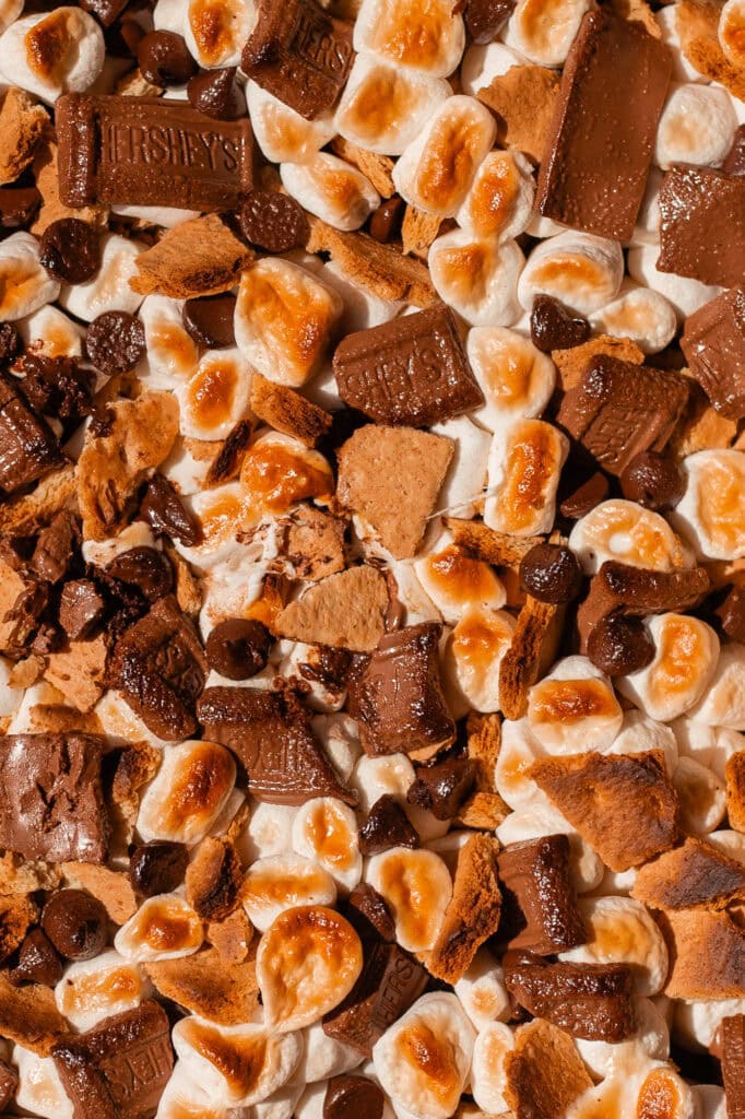 A close up shot showing the browned texture of marshmallows, chocolate, and graham crackers after broiling. 