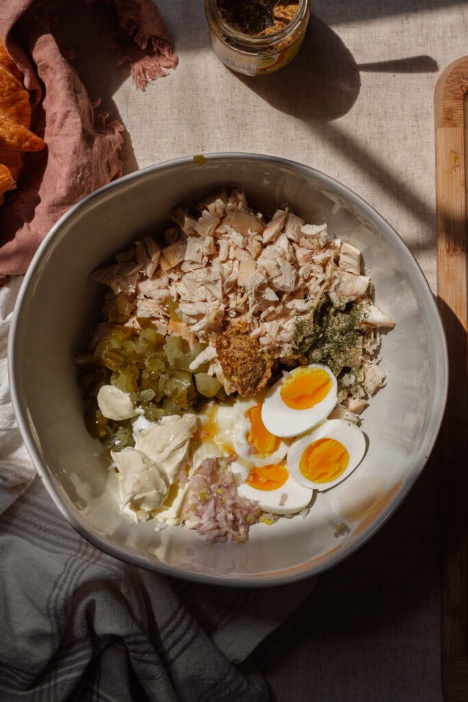 All the ingredients for dill pickle chicken salad in a large white bowl before mixing.