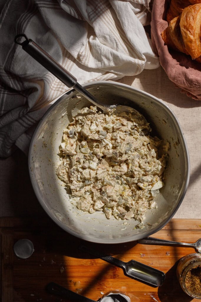 creamy, textured dill pickle chicken salad, evenly combined in a large white bowl and ready for serving.