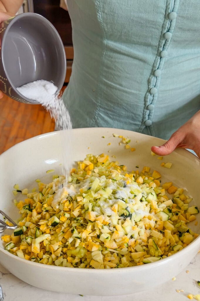 Salt is poured in a bowl with the cut vegetables